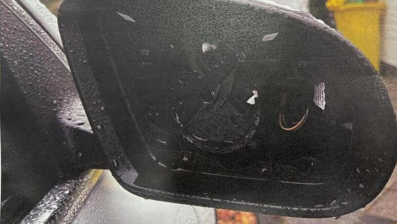 Ein ausgebauter Au&szlig;enspiegel an einem im Stadtgebiet am Stra&szlig;enrand abgestellten Auto.