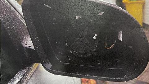 Ein ausbauter Au&szlig;enspiegel an einem im Stadtgebiet am Stra&szlig;enrand abgestellten Auto.