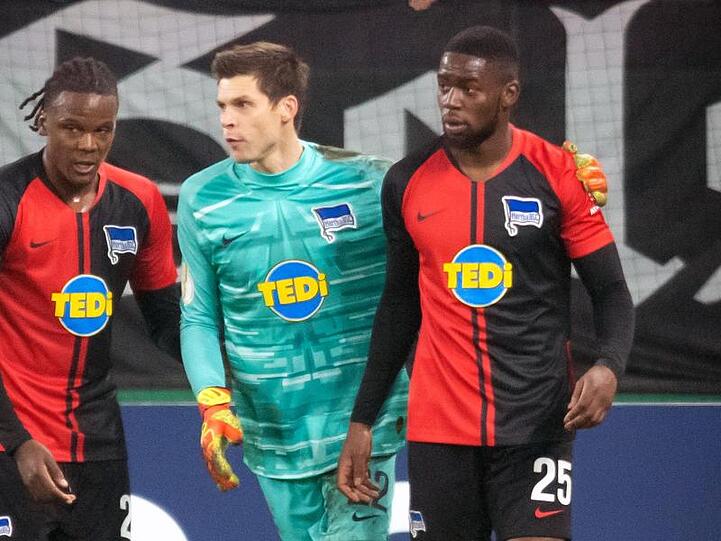 Herthas Dedryck Boyata (l-r) und Rune Jarstein nehmen Jordan Torunarigha vor der Schalker Nordkurve in Schutz.