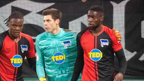 Herthas Dedryck Boyata (l-r) und Rune Jarstein nehmen Jordan Torunarigha vor der Schalker Nordkurve in Schutz.