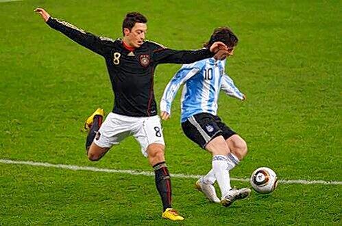 Mesut Özil (l.), hier gegen Lionel Messi beim Länderspiel gegen Argentinien im März, spielt &bdquo;wie ein Südamerikaner, könnte auch als Argentinier durchgehen&ldquo;.