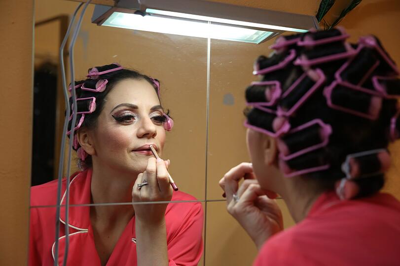 Chichi Bowet von The Filly Follies zieht vor ihrem Auftritt noch einmal den Lippenstift nach &ndash; es soll schließlich glamourös werden.