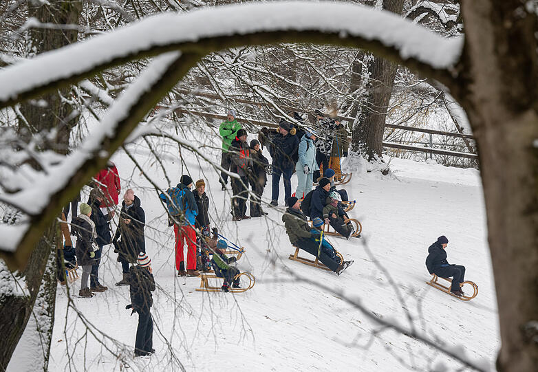 Der Schneefall in München hat auch etliche Menschen auf die Rodelhügel gelockt.