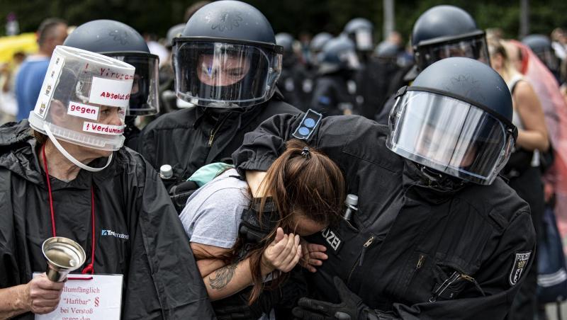 Polizisten nehmen an der Siegessäule eine Demonstrantin fest.
