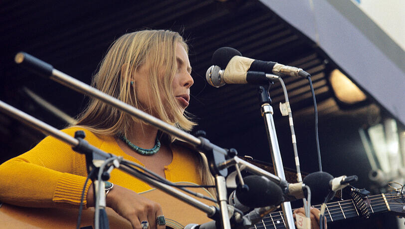 Die kanadische Liedermacherin Joni Mitchell beim Isle of Wight Festival (1970). Die kanadische Liedermacherin Joni Mitchell beim Isle of Wight Festival (1970).