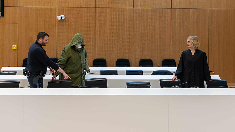 Ein wegen sexuellen Kindesmissbrauchs angeklagter Mann (56) wird zu Prozessbeginn am Landgericht München II in den Saal geführt. Rechts steht seine Anwältin Anja Kollmann.