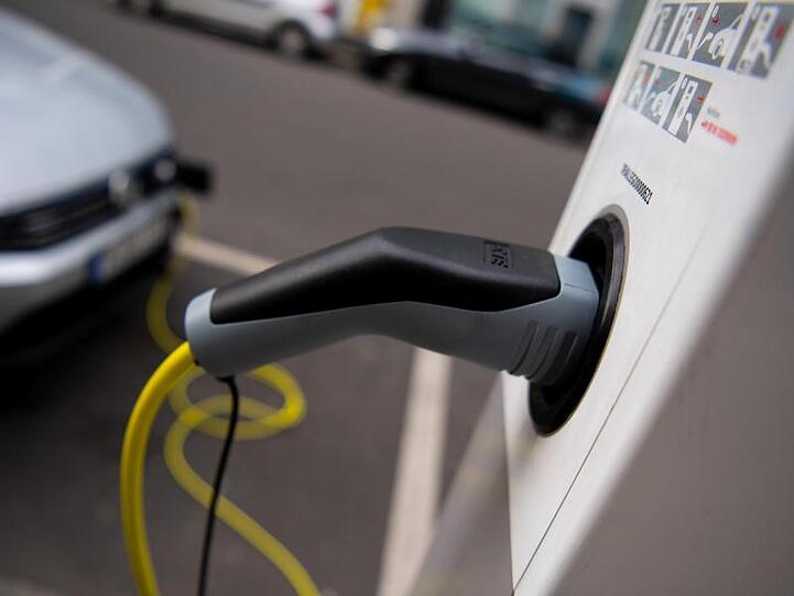 Ein Auto wird an einer Ladesäule für Elektrofahrzeuge geladen.