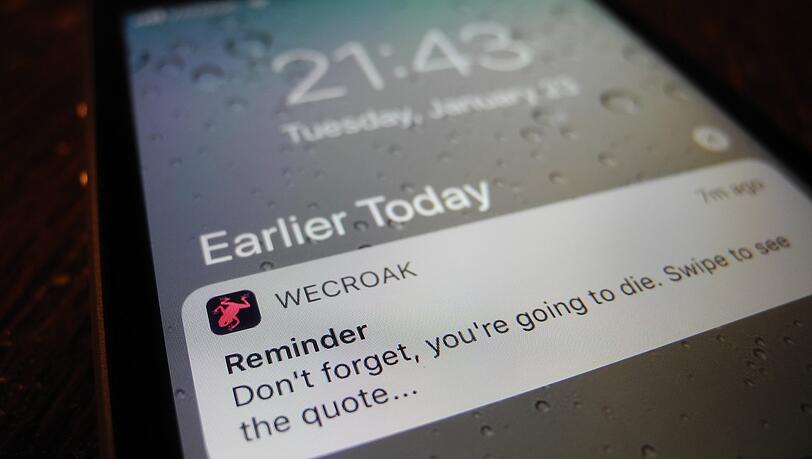 Ein Handy mit einer Benachrichtigung der Smartphone-App "WeCroak", die Handynutzer mehrmals täglich an den sicheren Tod erinnert. Ein Handy mit einer Benachrichtigung der Smartphone-App "WeCroak", die Handynutzer mehrmals täglich an den sicheren Tod erinnert.