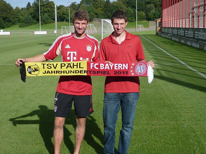Thomas Müller und sein Bruder Simon präsentieren den Schal zum Freundschaftsspiel der Bayern gegen Pähl