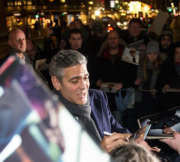 Der US-amerikanische Schauspieler George Clooney gibt am 08.02.2014 vor dem Restaurant Bocca di Bacco in Berlin Autogramme. Dort feierte er die Berlinale-Premiere des Films "The Monuments Men" mit geladenen Gästen.