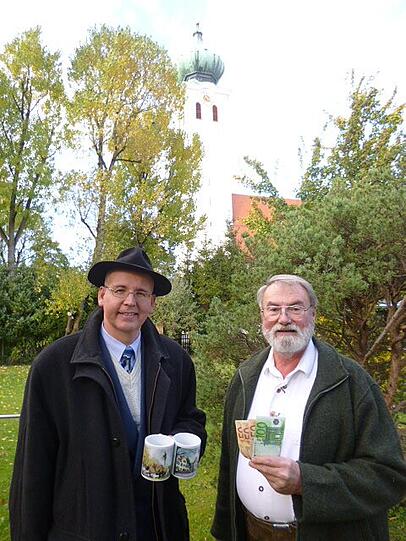 Friedrich Huber übergibt Pfarrer Harald Wechselberger die Spende für die Kirche.