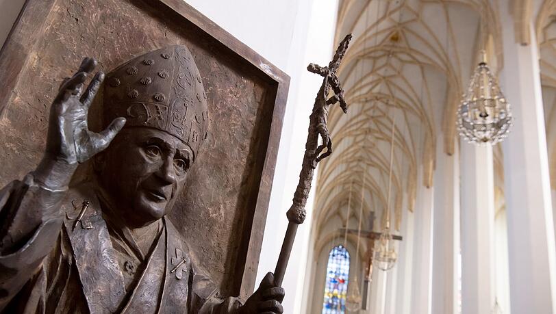 Ein Relief von Papst Benedikt XVI. ist in der Münchner Frauenkirche zu sehen. Nach der Vorstellung eines Gutachtens zu sexueller Gewalt im Erzbistum München und Freising müssen Standesämter in Bayern sich für eine Flut von Kirchenaustritten rüsten.