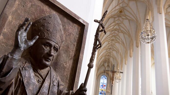 Ein Relief von Papst Benedikt XVI. ist in der Münchner Frauenkirche zu sehen. Nach der Vorstellung eines Gutachtens zu sexueller Gewalt im Erzbistum München und Freising müssen Standesämter in Bayern sich für eine Flut von Kirchenaustritten rüsten.