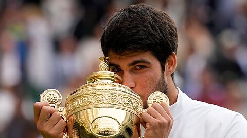 Liebkosung f&uuml;r den Pokal: Tennisprofi Carlos Alcaraz freute sich sichtlich &uuml;ber den Sieg im Wimbledon-Final 2023. (Archivbild)