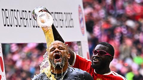 Bayern-Trainer Vincent Kompany bekommt eine Bierdusche von Abwehrspieler Dayot Upamecano.