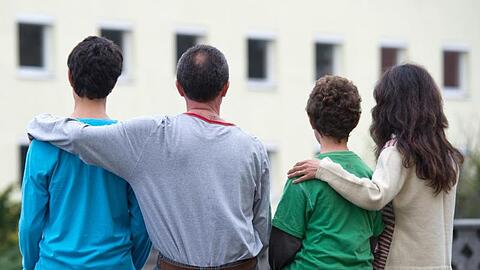 Eine syrische Familie sitzt vor einem Asylwohnheim im brandenburgischen Eisenhüttenstadt.