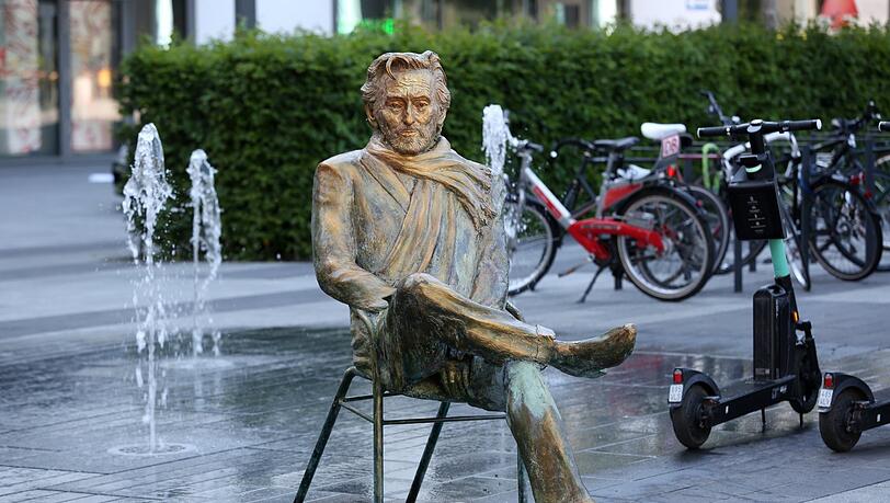 Hier sitzt Helmut Dietl - zwischen Wasserspiel und E-Scootern. Hier sitzt Helmut Dietl - zwischen Wasserspiel und E-Scootern.