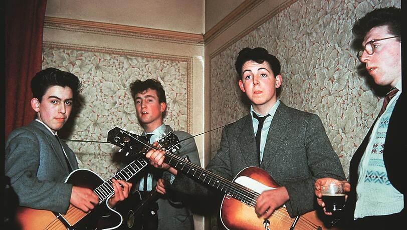 George Harrison (links), John Lennon und Paul McCartney 1958 bei Pauls Tante Jin in Liverpool. Der Zuhörer heißt Dennis und ist ein Freund von Tante Jins Sohn.