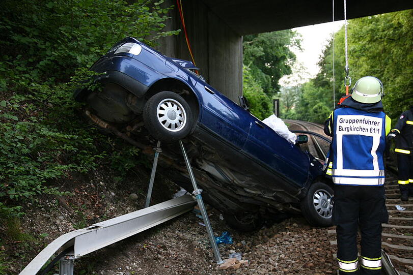 Furchtbarer Unfall im Landkreis Altötting: Ein PKW fliegt von einer Brücke herunter und knallt auf das Gleisbett. Drei junge Menschen kommen schwer verletzt in die Klinik.