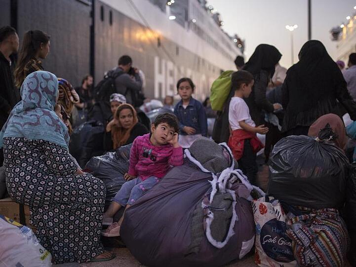 Flüchtlinge und Migranten verlassen im Hafen von Piräus eine Fähre.
