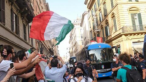 Fans jubeln dem Bus der italienischen Fußballnationalmannschaft zu, der kaum durch die Straßen Roms kommt.