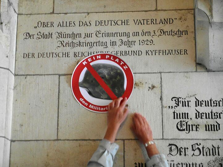 Die Gedenktafel wird um eine pazifistische Komponente ergänzt
