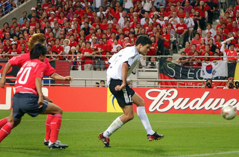 WM, 2002: Halbfinale gegen Südkorea 1:0 - In Seoul spielt Deutschland gegen eine rote Wand. Es steht noch 0:0 als Michael Ballack seine zweite Gelbe Karte des Turniers sieht - das Finale ist für ihn perdu. Doch der beste deutsche WM-Spieler macht noch das Siegtor. Beim 0:2 im Endspiel gegen Brasilien fehlt er sehr.