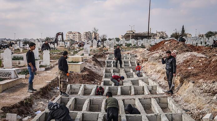 Syrer präparieren entlang der türkisch-syrischen Grenze Gräber für ihre Angehörigen, die bei dem verheerenden Erdbeben ums Leben gekommen sind. Syrer präparieren entlang der türkisch-syrischen Grenze Gräber für ihre Angehörigen, die bei dem verheerenden Erdbeben ums Leben gekommen sind.