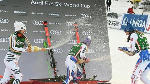Viktoria Rebensburg (r) duscht Tessa Worley (M) und Petra Vlhova mit Champagner ab.