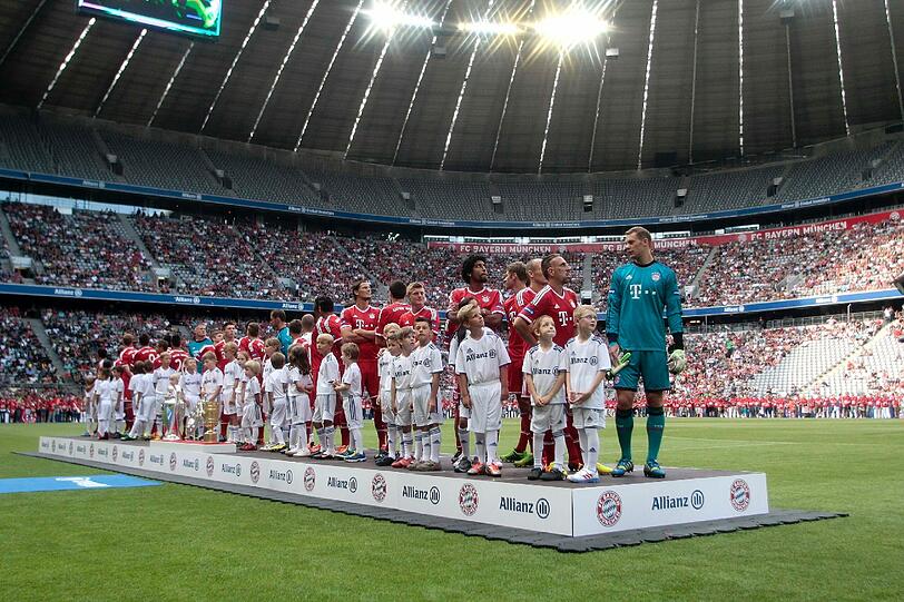 Große Bühne in Fröttmaning: Die Bayern-Profis mitsamt den drei Titeln der Vorsaison.