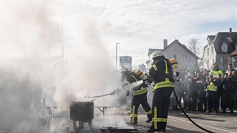 Einsatzkräfte der Feuerwehr löschen ein Feuer vor der Stadthalle.