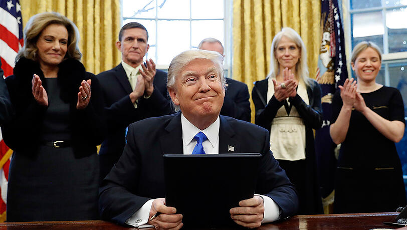 Präsident Donald Trump lächelt nach der Unterzeichung von drei Exekutiv Aktionen im Oval Office vom Weißen Haus. Präsident Donald Trump lächelt nach der Unterzeichung von drei Exekutiv Aktionen im Oval Office vom Weißen Haus.
