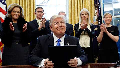 Präsident Donald Trump lächelt nach der Unterzeichung von drei Exekutiv Aktionen im Oval Office vom Weißen Haus.