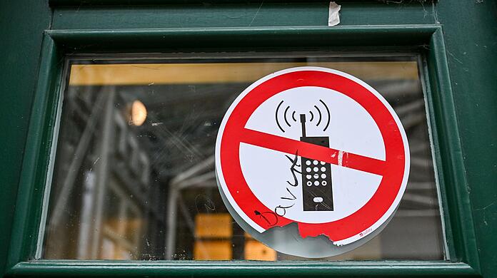 Bisher ist das Mitbringen der Telefone in den Unterricht erlaubt, ihre Nutzung aber untersagt. (Symbolbild)