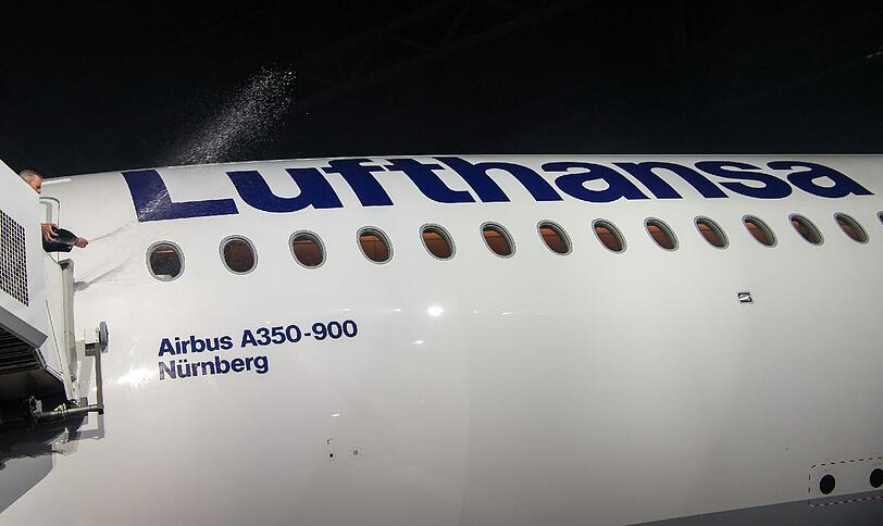 Der Nürnberger Oberbürgermeister Ulrich Maly tauft die neue Lufthansa-Maschine mit einer Flasche Sekt.