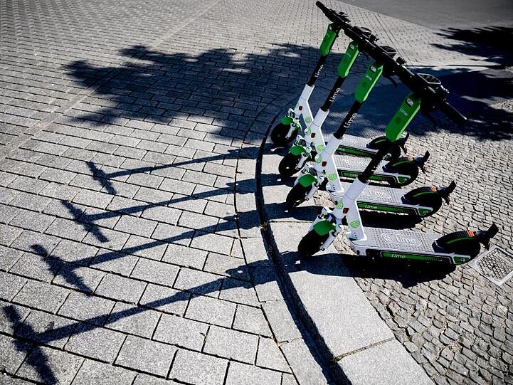 E-Tretroller der US-Firma Lime stehen in Berlin zum Verleih bereit.
