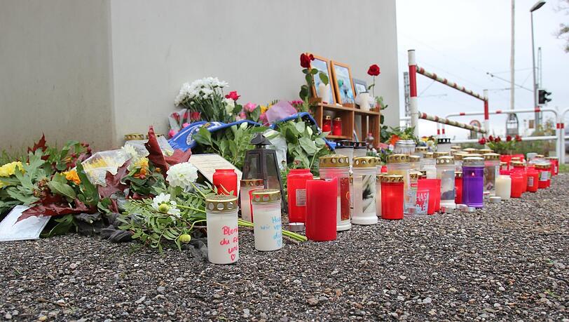 Fotos der tödlich verunglückten Brüder Hasan und Blerian stehen am Bahnhof in Bruckberg umrahmt von Kerzen und Blumen.