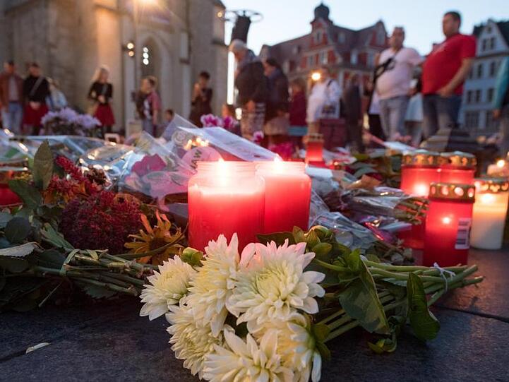 Menschen kommen nach einem ökumenischen Gedenkgottesdienst für die Opfer des Terroranschlags in Halle vor der Marktkirche in Halle (Saale) zusammen und stellen Kerzen ab.