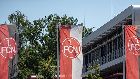 Fahnen mit dem FCN-Logo wehen vor dem Vereinsgebäude.