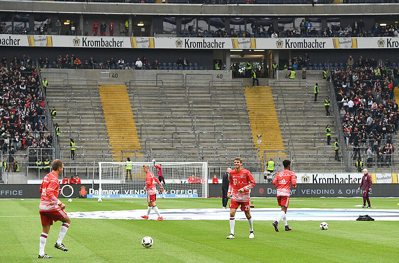 Die Bayern-Spieler beim Aufwärmen vor dem leeren Fanblock 40.