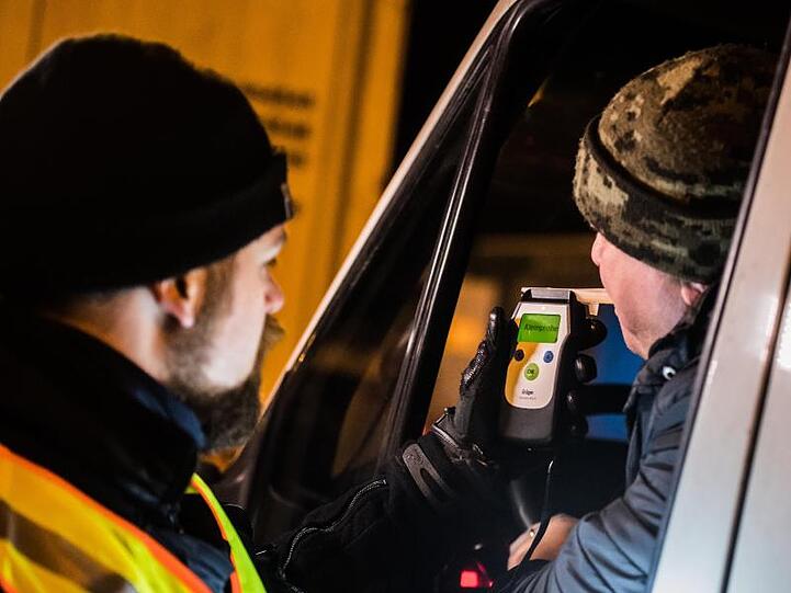 Ein Polizist kontrolliert einen LKW-Fahrer auf Alkoholgenuss. Foto: Andreas Arnold/Archiv