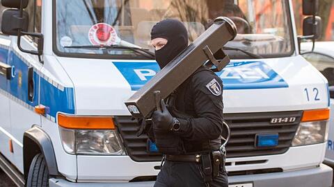 Ein Polizeibeamter trägt nach einer Razzia im Märkischen Viertel in Berlin eine Ramme.