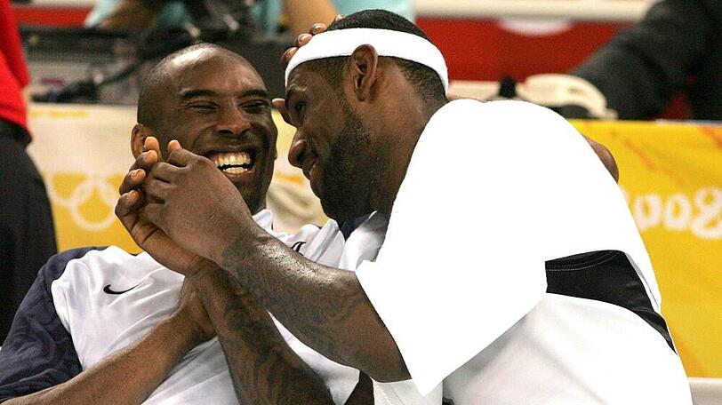 Kobe Bryant (l.) und LeBron James scherzen gemeinsam auf der Auswechselbank während den Olympischen Spielen von Peking