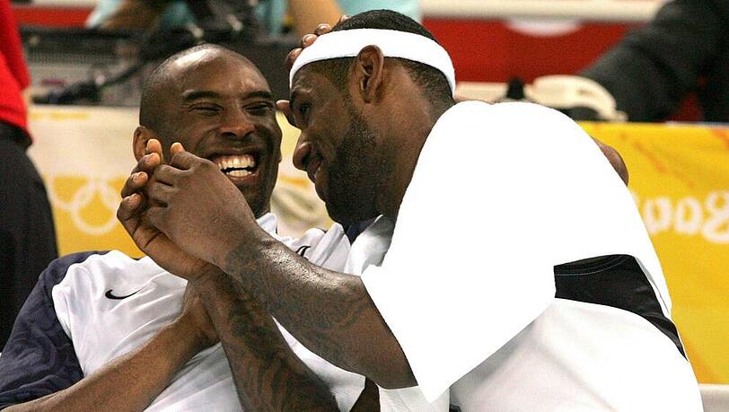 Kobe Bryant (l.) und LeBron James scherzen gemeinsam auf der Auswechselbank während den Olympischen Spielen von Peking Kobe Bryant (l.) und LeBron James scherzen gemeinsam auf der Auswechselbank während den Olympischen Spielen von Peking