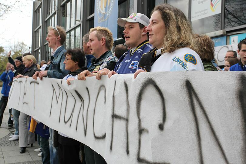 "Rettet München", "Kämpft um unser Leben" und "Der EHC sind nur wir": Das steht auf den Bannern der Fans des EHC. Vor der Olympia-Eishalle demonstrieren sie gegen das Aus des Münchner Eishockey-Vereins.