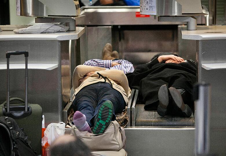 Nicht die beste Art eine Nacht zu verbringen: Gestrandete Passagier schlafen am Frankfurter Flughafen auf Gepäckbändern (Archivbild).