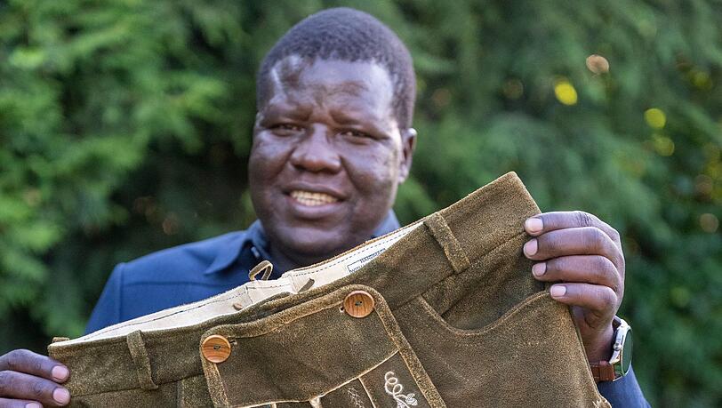 Alfred Okwonga, Bürgermeister der Stadt Gulu in Uganda, zeigt die ersten ugandisch-bayersichen Lederhosen.
