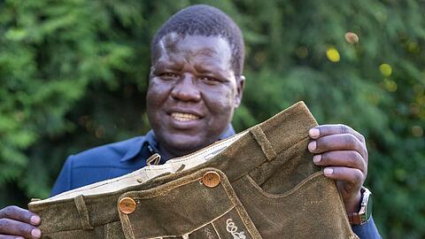 Alfred Okwonga, Bürgermeister der Stadt Gulu in Uganda, zeigt die ersten ugandisch-bayersichen Lederhosen.