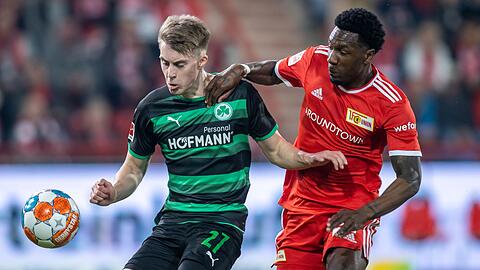 Luca Itter von Greuther Fürth kämpft gegen Berlins Sheraldo Becker (r) um den Ball.