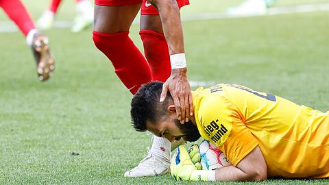 Der Augsburger Torwart Tomas Koubek (unten) hält den Ball Sekunden vor dem Abpfiff fest.